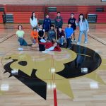 Middle Schoolers pose with new Firedragon logo in the gym of the Ang Athletic Center