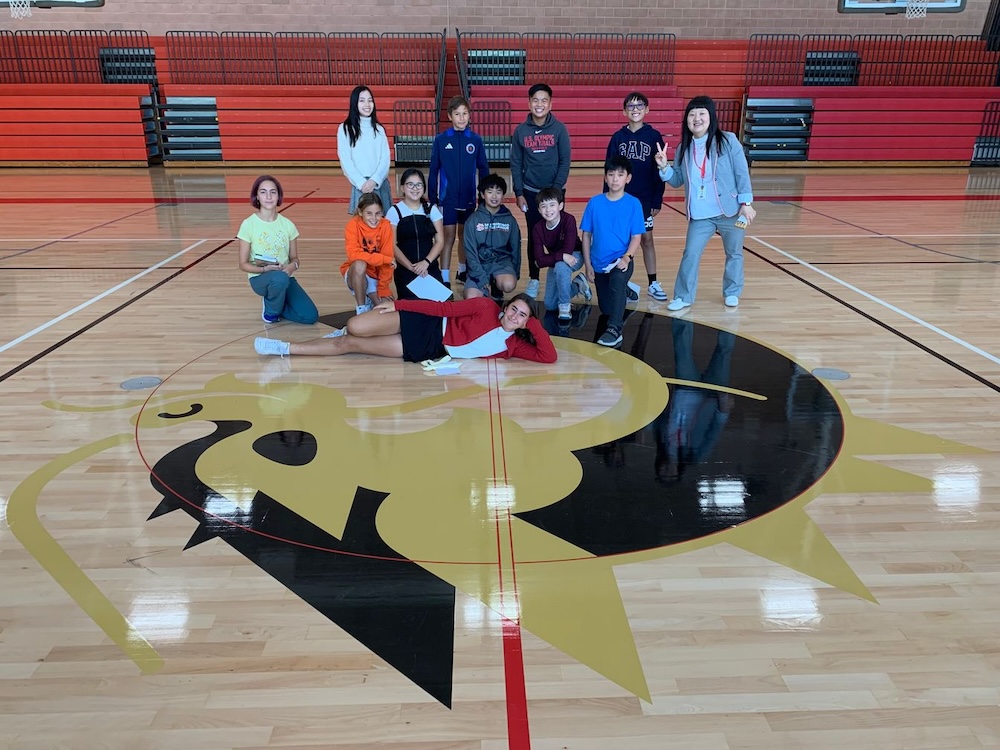 Middle Schoolers pose with new Firedragon logo in the gym of the Ang Athletic Center